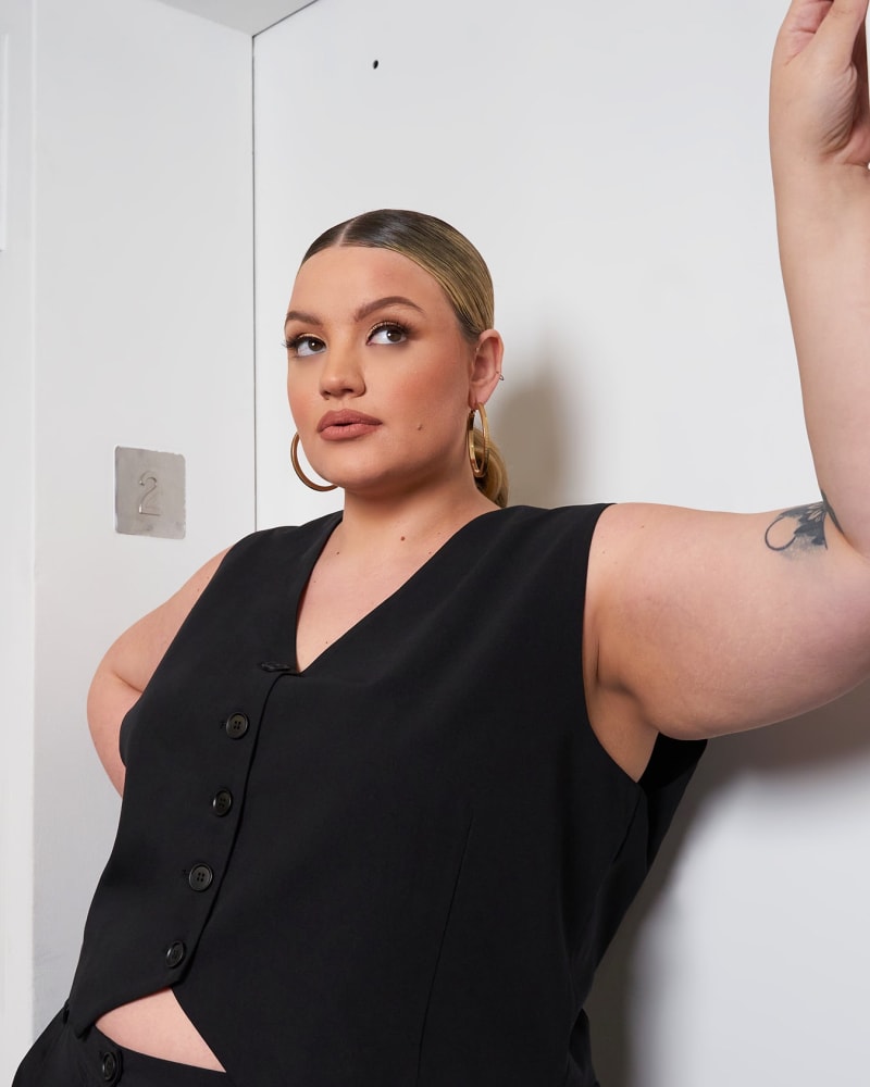 Side of a model wearing a size 5X Office Babe Button Up Vest - Black in Black by Rebdolls. | dia_product_style_image_id:321602